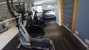 Ein Fitnessstudio mit Laufbändern und Crosstrainern.