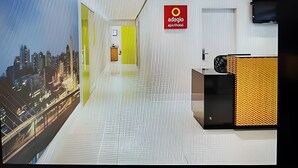 Eine moderne Hotelhalle mit Blick auf die Stadt, ein Empfangstresen und ein Schild mit der Aufschrift "odagio".
