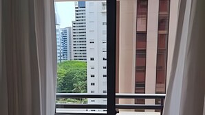 Ein Balkon mit Blick auf hohe Gebäude und Grünflächen.