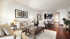 Un salon moderne comprenant un canapé, des fauteuils, une table basse et un coin repas avec des chaises et une table.