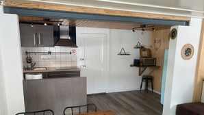 A compact kitchen with a central island, a dining table, and a small seating area.