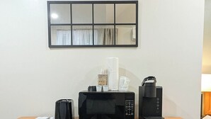A wooden dresser with a microwave, a coffee maker, and a small stack of cups. - New Cabin for your Holiday_Cabin 12B (Bar Harbor)