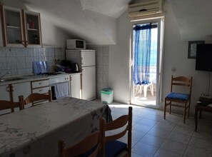 Enjoy meals in the kitchen with a microwave, refrigerator, and sink, adjacent to a dining area with a table for two.