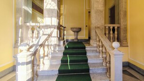 A grand staircase with marble steps and wooden balustrades, leading to a bright interior space. - Private parking & air conditioning, 10 minutes walk from center (Genoa)