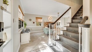 A spacious interior with a staircase, a fireplace, and a view of the outdoors. - Orange Grove (Melbourne)