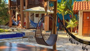 Zona de piscina con una hamaca colgante, una mesa y una hamaca.