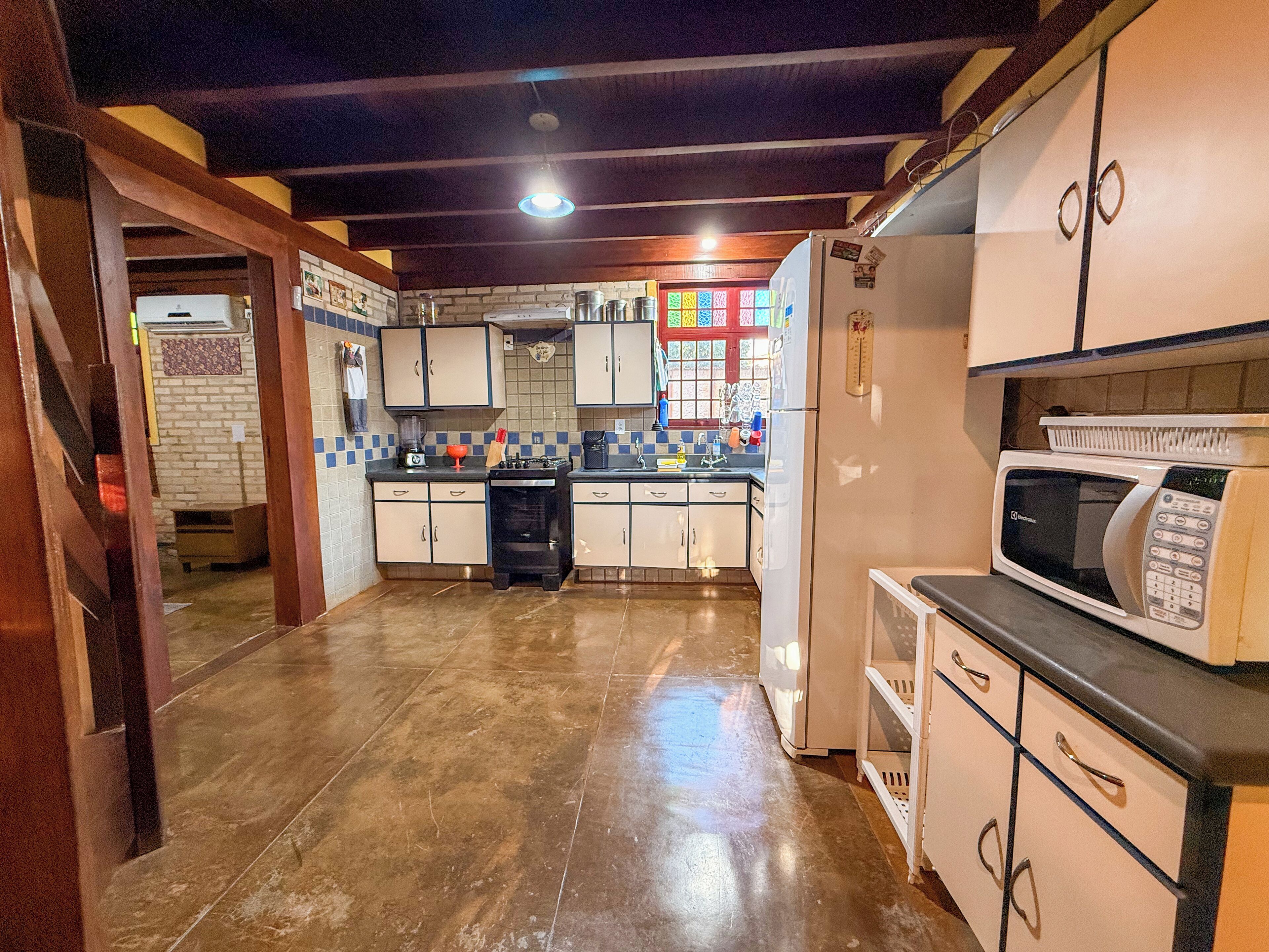 A compact kitchen with a refrigerator, microwave, and stove.