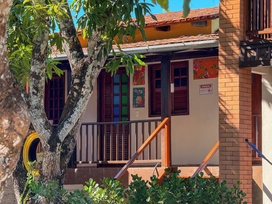 A building with a wooden staircase, a tree in front, and a colorful wall with a sign.