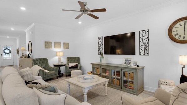 A living room with a sofa, armchairs, a coffee table, a TV, and a cabinet with baskets. - Family Affair (Santa Rosa Beach)
