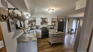 A modern kitchen with white cabinetry, a granite countertop, and a built-in oven. - 4BR, 3.5 BA House, great sunset view, close to town. (Nashville)