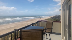 Un balcon avec vue sur la plage et l’océan.