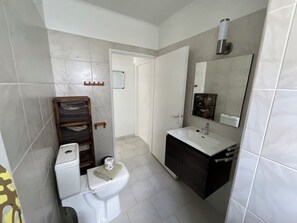 A bathroom with a toilet, sink, mirror, and towel rack. - Apartment on gated resort, minutes from beautiful beaches (Sint Michiel)