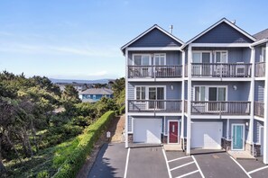 Un immeuble résidentiel à plusieurs étages, doté d’un garage et d’une porte rouge.
