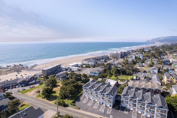 Un quartier résidentiel situé sur la côte, avec une plage, des maisons et un parking.