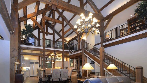 A spacious interior with a high ceiling, wooden beams, a chandelier, a staircase, and a dining area. - Timberhaven (Crested Butte)