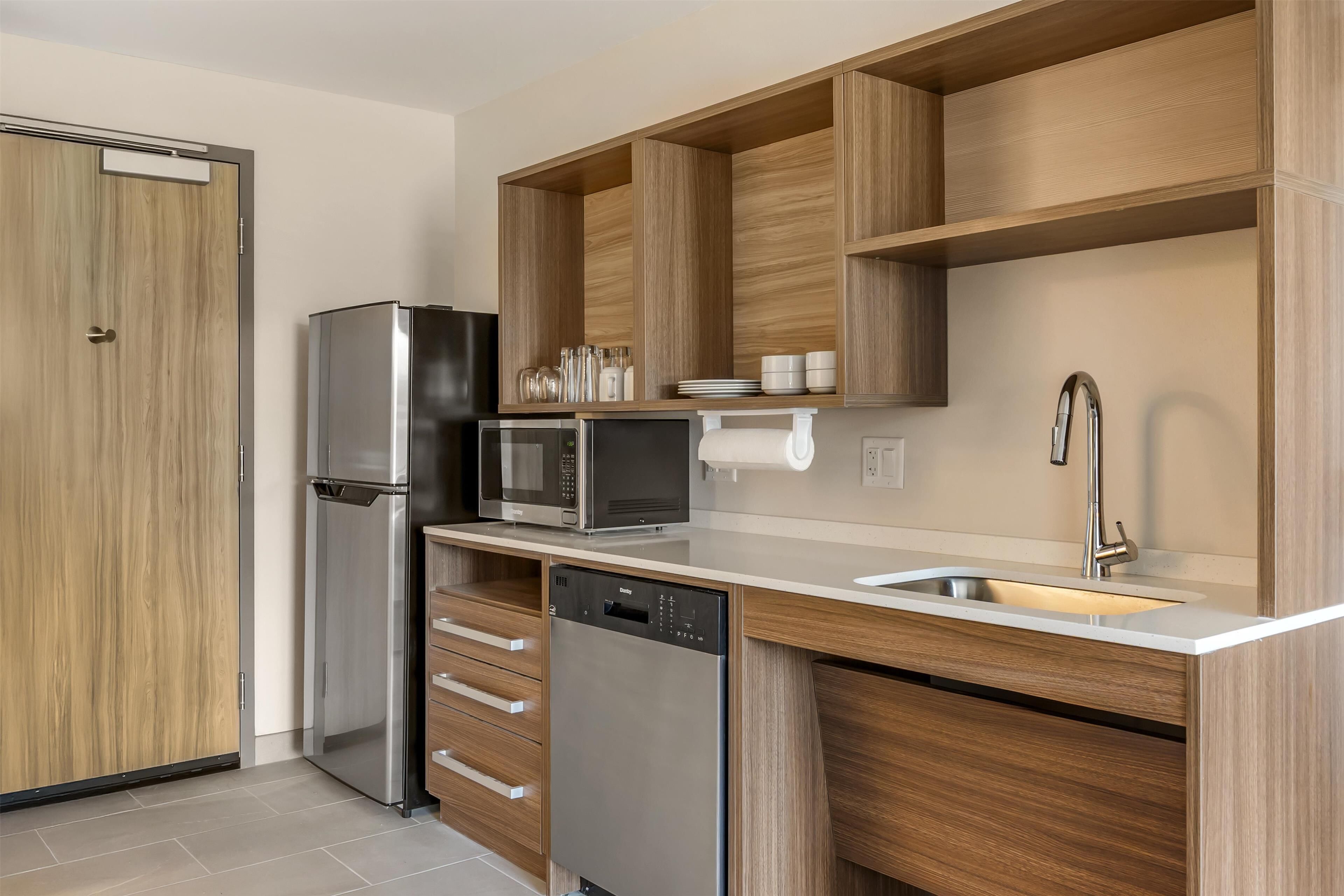 Una cocina moderna con armarios de madera, electrodomésticos de acero inoxidable y un lavavajillas integrado.