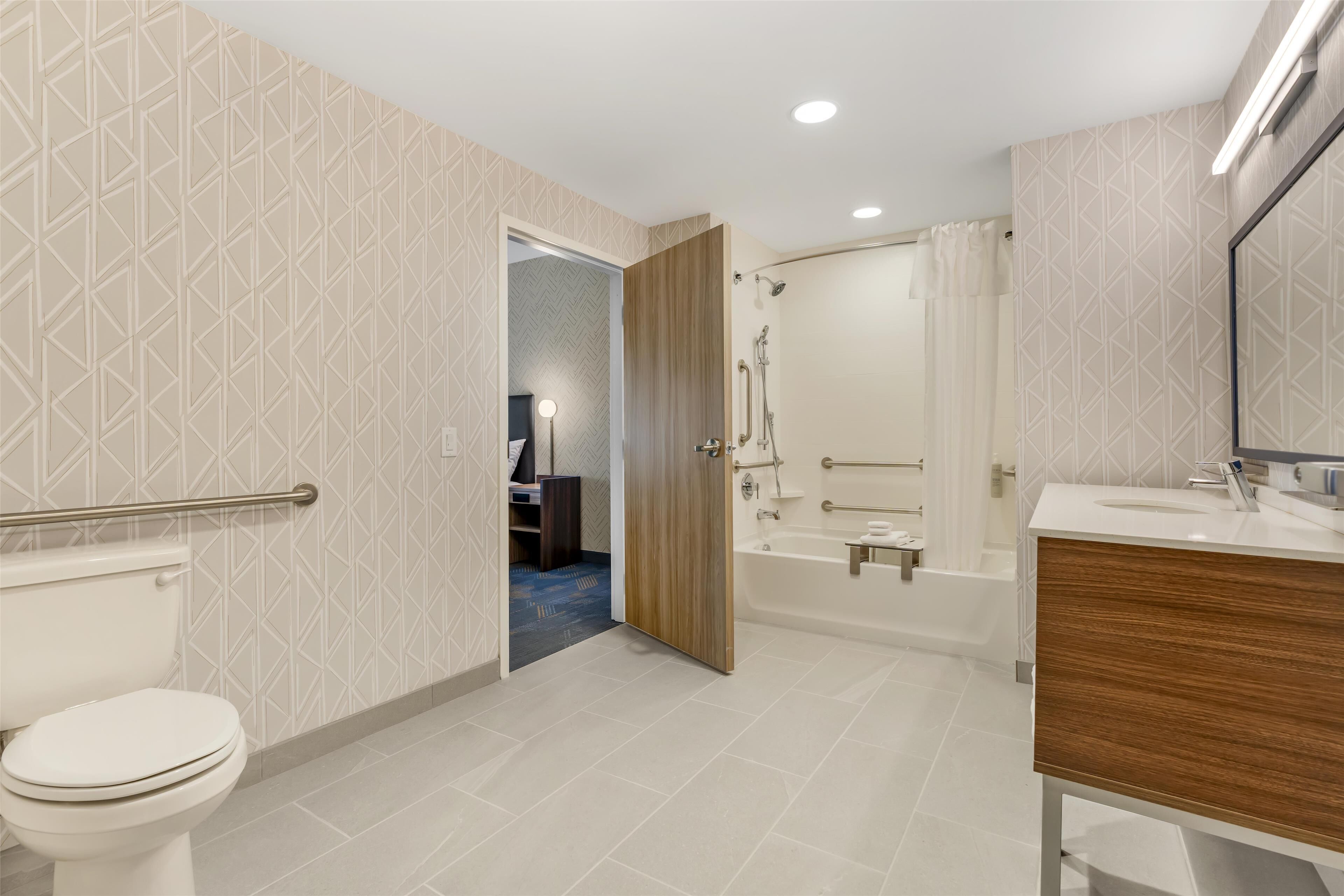 Un baño moderno con inodoro, ducha y lavamanos.