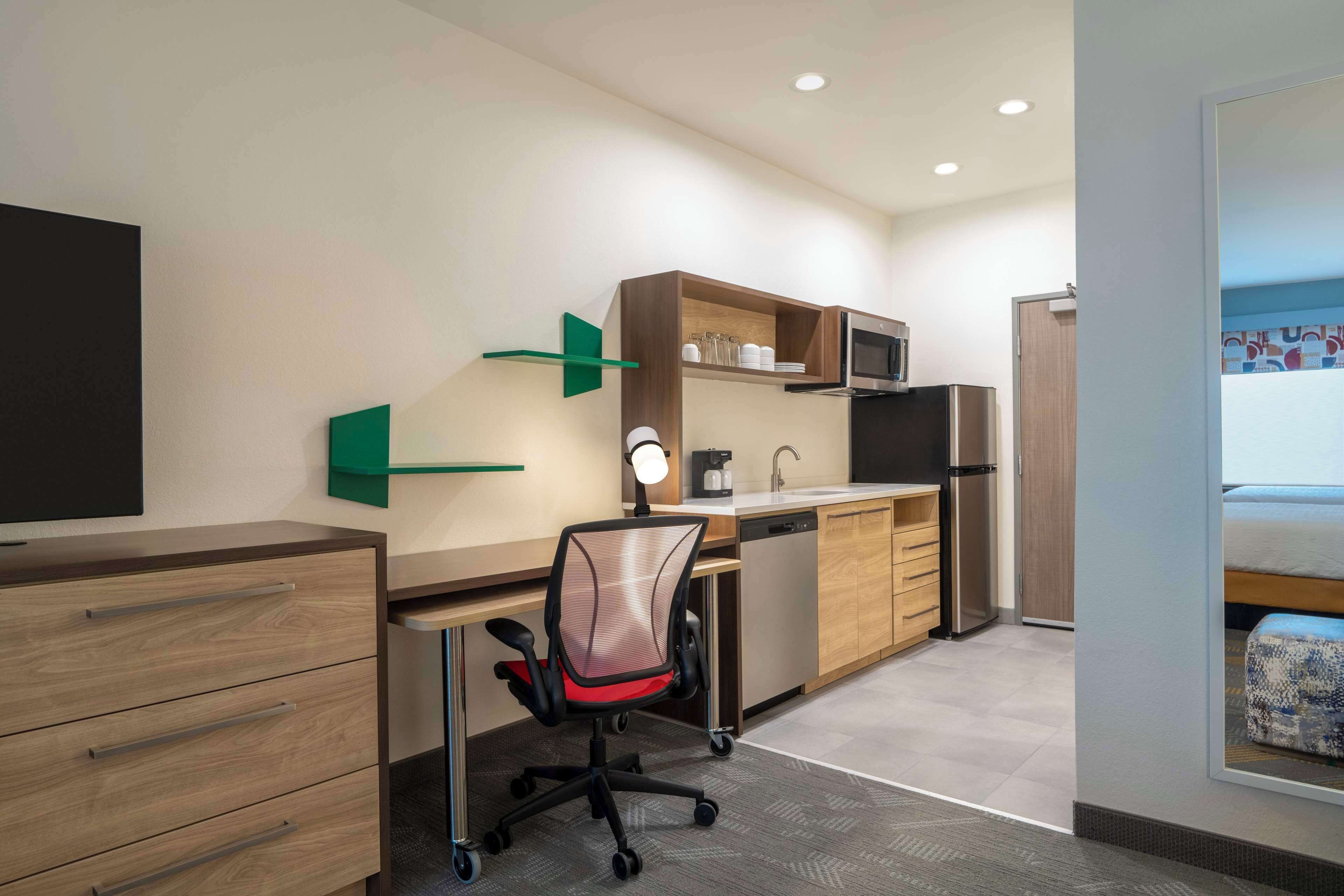 Una cocina moderna con microondas, refrigerador y armarios de madera.