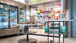 A grocery store interior with refrigerated sections, shelves stocked with snacks, and a checkout area. - Home2 Suites By Hilton Effingham (Effingham)