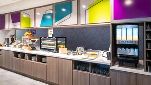 A modern breakfast bar with a coffee machine, fruit display, and various food items. - Home2 Suites By Hilton Effingham (Effingham)