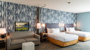 A hotel room with a large bed, a sofa, a small table, and a wall-mounted TV. - Home2 Suites By Hilton Effingham (Effingham)