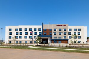 Un hotel moderno con techo plano, varios pisos y una entrada destacada.