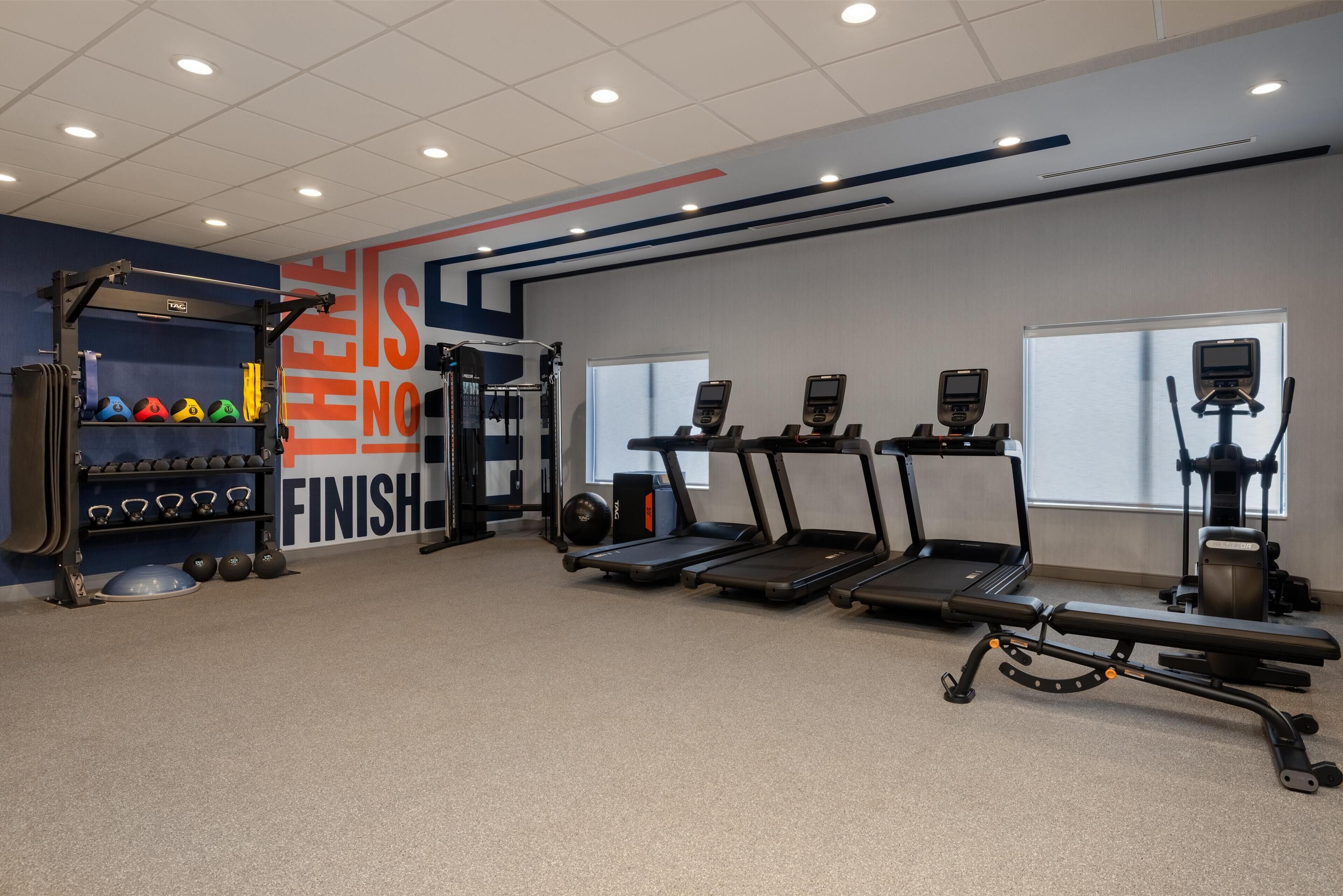 A gym with treadmills, weight machines, and a squat rack.