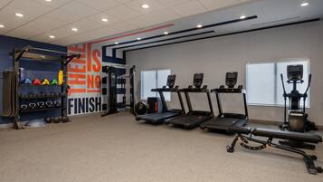 A gym with treadmills, weight machines, and a squat rack.