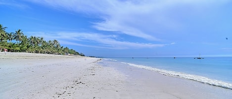 On the beach, white sand, sun loungers, beach umbrellas
