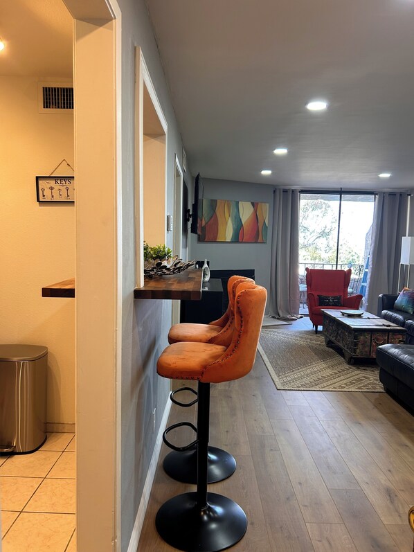 A modern living room with a wooden floor, a red armchair, a black sofa, and a coffee table. - Hillside + View+ First Level + Pool + Remodeled!
Close to USC Keck & Attractions (Los Angeles)