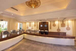 Un buffet avec plusieurs distributeurs de nourriture et un espace central pour servir les plats.