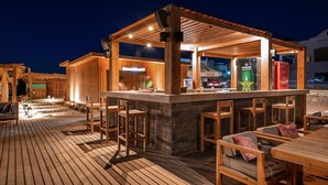 An outdoor bar area with wooden furniture and a stone counter. - Paradise Kitesurfing Hotel (Ras Sudr)