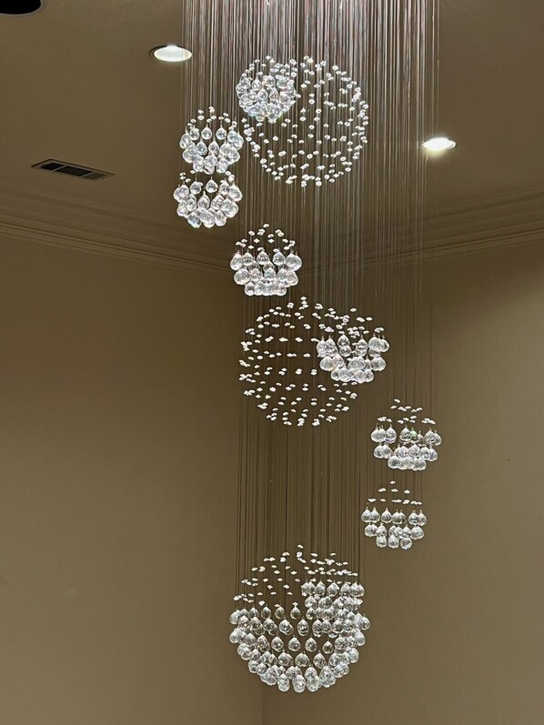 A chandelier with multiple tiers of clear crystal decorations.