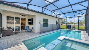 Una piscina exterior cubierta con zona de patio, que incluye asientos y un ventilador de techo.