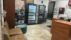 Un espace bar où l’on peut prendre un café, avec un distributeur automatique de boissons froides et une machine à café.