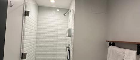 A bathroom with a shower, toilet, and sink.