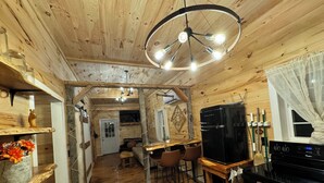 L’intérieur d’un chalet en bois chaleureux et accueillant, comprenant un coin repas, une cuisine et un espace de vie.