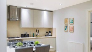 Een moderne keuken met een eetgedeelte, roestvrijstalen apparatuur en een witte radiator.