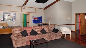 Una sala de estar con un sofá cómodo, una mesa de centro y una bandera en la pared.