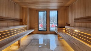 Un sauna con bancos de madera y ventanas amplias.