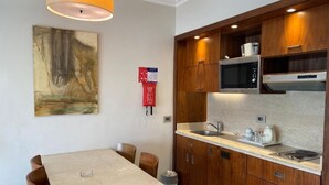 Een moderne keuken met houten kastjes, een ingebouwde magnetron en een roestvrijstalen spoelbak.