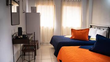 A room with two beds, a desk, and a chair.