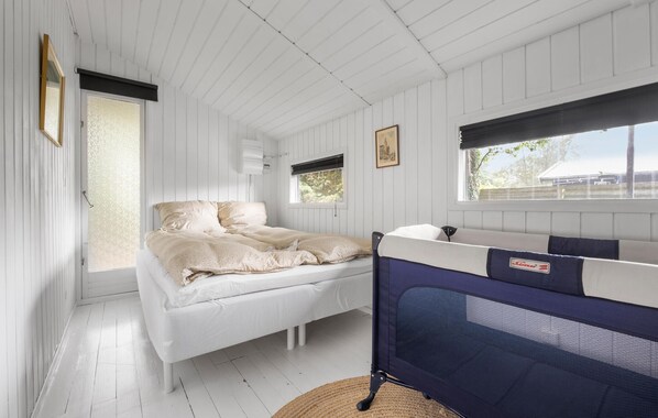 A room with a bed, a window, and a bunk bed.