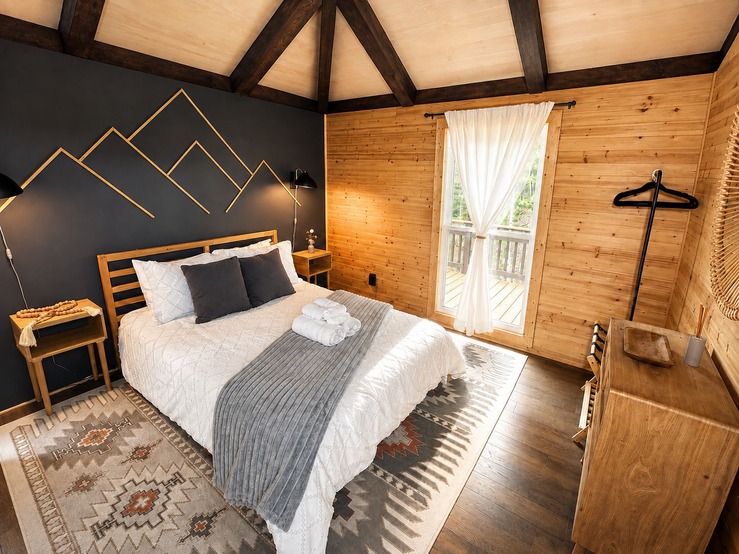 Een slaapkamer met een bed, nachtkastjes, een hanglamp, een raam met gordijnen, een houten dressoir en een kamerbreed vloerkleed.