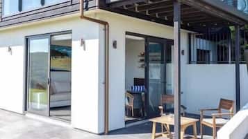 A modern building with a covered patio area featuring a table and chairs.