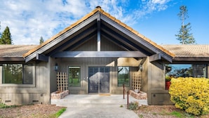 A modern two-story house with a prominent front porch, a large garage door, and a well-maintained lawn.