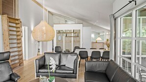 A modern living room with a sofa, chairs, a coffee table, and a dining area. - Gorgeous home in Væggerløse with sauna (Væggerløse)