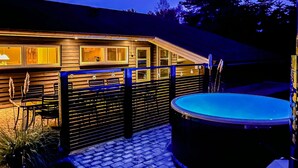 A wooden house with a pool, a fenced patio, and a visible kitchen area. - Gorgeous home in Væggerløse with sauna (Væggerløse)