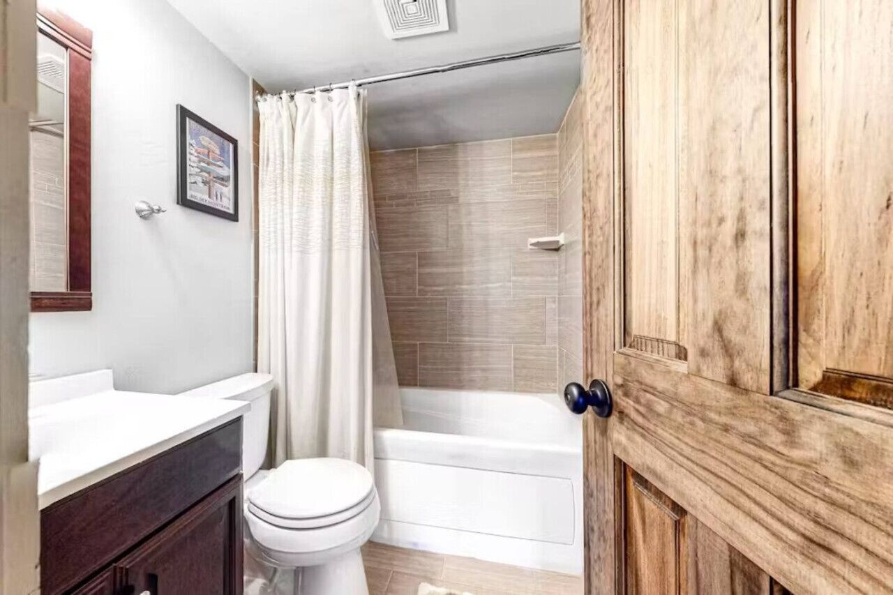 Un baño con inodoro, lavamanos y zona de ducha.