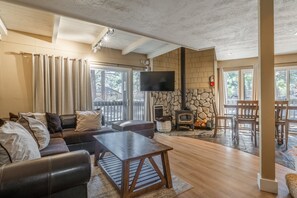 A spacious living room with a stone fireplace, a flat-screen TV, and a cozy seating area.